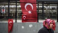 FILE PHOTO: A woman stands in front of Turkish national flags displayed at the site of the December 10 blasts outside Besiktas Vodafone Arena football stadium on December 13, 2016 in Istanbul (AFP / OZAN KOSE) 