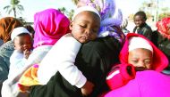 African migrants carry their children as they wait to be deported at Mitiga International Airport, east of Tripoli, yesterday.
