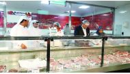 Inspectors checking meat at a butchery. 