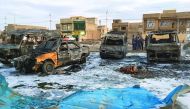 A picture taken with a mobile phone on February 16, 2017 shows burnt vehicles at the scene of a blast by a massive car bomb, which killed dozens in a used car market in southern Baghdad. The Amaq propaganda agency linked to the Islamic State group (IS), w