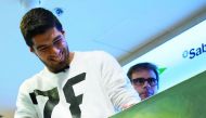 Barcelona striker Luis Suarez smiles as he looks at a caricature of himself by Spanish cartoonist Vizcarra during the presentation of the 12th edition of the book 