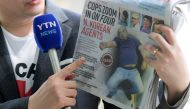 A reporter holds up a local newspaper during his report in front of the morgue at Kuala Lumpur General Hospital where Kim Jong Nam's body is held for autopsy in Malaysia February 18, 2017. REUTERS/Athit Perawongmetha