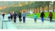 Fitness enthusiasts in warm clothing walk along the Doha Corniche during a windy and cold evening yesterday. Pic: Kammutty VP / The Peninsula