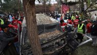 Pakistani volunteers examine the wreckage of a vehicle after a suicide bomb attack in Peshawar on February 15: ABDUL MAJEED / AFP.