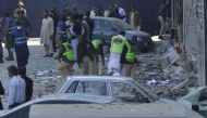 Pakistani security officials examine the site after a bomb attack in Lahore on February 23, 2017.   AFP / ARIF ALI
