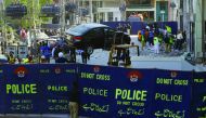 Pakistani security officials examine the site after a bomb attack in Lahore, yesterday.