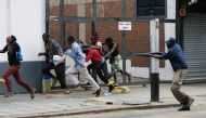 A South African riot policeman fires rubber bullets to disperse South African nationals during a protest march against illegal immigrants in Pretoria, South Africa, yesterday.
