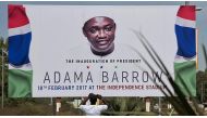 A man takes a photo of a billboard prepared for an invitation of the event which held at Independence Stadium on February 18, for Gambia's president Adama Barrow, at Banjul International Airport in Banjul, Gambia on January 26, 2017. ( Xaume Olleros - Ana