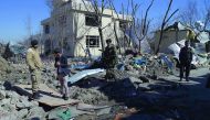 Afghan security personnel walk through the wreckage of the district police headquarters in Kabul, yesterday, a day after a suicide car bomb attack. 