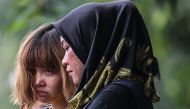 Vietnamese national Doan Thi Huong (L), 28, is escorted with a heavy police presence after a court appearance with Indonesian national Siti Aisyah, 25, at the magistrates' court in Sepang on March 1, 2017, for their alleged role in the assassination of Ki