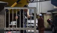 A Malaysian policeman wipes his face as he holds the gate of the forensics wing of the Hospital Kuala Lumpur where the body of Kim Jong-Nam, the half-brother of North Korean leader Kim Jong-Un, is being kept in the Malaysian capital on March 4, 2017. / AF