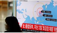 A woman walks past a television broadcasting a news report on North Korea firing ballistic missiles, at a railway station in Seoul on Mar 6, 2017. (Photo: Reuters).