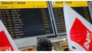 Members of Germany's Verdi union protest with flags in front of a display with canceled flights during a warning strike by ground services, security inspection and check-in staff at Tegel airport in Berlin, Germany March 10, 2017. REUTERS/Hannibal Hanschk