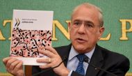 FILE PHOTO: OECD Secretary General Angel Gurria holds up a copy of the Japan 2016 OECD Territorial Review during a press conference in Tokyo on April 11 2016 AFP TORU YAMANAKA