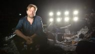 Swiss theatre director Milo Rau posing for photographs on a set created for his play 