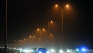 Vehicles moving on Wakrah highway last night, as dust blanketed the city and other parts of the country yesterday, following strong winds. Pic: Abdul Basit/The Peninsula