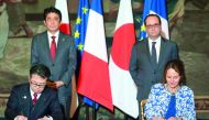 French Ecology Minister Segolene Royal (right) and Japanese Economy, Trading and Industry Minister Hiroshima Seko sign an agreement in front of French President Francois Hollande and Japanese Prime Minister Shinzo Abe at the Elysee Palace in Paris, France