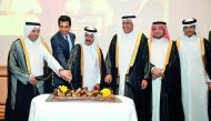 H E Dr Mohammed Abdul Wahed Ali Al Hammadi (left), Minister of Education and Higher Education, and Secretary-General of Qatar's Foreign Ministry, Dr Ahmad bin Hassan Al Hamadi (third left), cutting the cake with Shahzad Ahmad, Ambassador of Pakistan, at a
