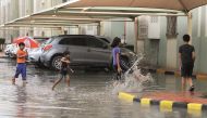 Children frolic in rain water at Ezdan Village Al Wukair, yesterday. Pic: Abdul Basit / The Peninsula