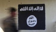 An Iraqi forces member walks past a wall painted with the black flag used by Islamic State militants at a hospital damaged by clashes in the Wahda district of eastern Mosul January 8, 2017 (REUTERS Alaa A)