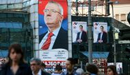 People walk past posters of Serbian Prime Minister and presidential candidate Aleksandar Vucic (R) and Vojislav Seselj in Belgrade, Serbia, March 31, 2017. Reuters/Antonio Bronic
