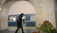 A woman places flowers in honour of the victims of the April 3 blast on the platform of Technological Institute metro station in Saint Petersburg on April 4, 2017.  AFP / Olga MALTSEVA
