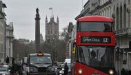 (FILES) This file photo taken on March 20, 2017 shows Union flags flying above and in front of Britain's Houses of Parliament as a black London taxi cab and red London bus wait at traffic lights in central London on March 20, 2017. AFP / Justin Tallis 
