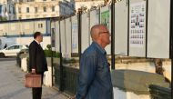 Algerian men look at electorial campaign posters for the upcoming legislative elections in Algiers' Martyrs Square as the official start of campaigning got underway on April 9, 2017. / AFP / RYAD KRAMDI / RYAD KRAMDI
