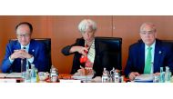 L-R) Jim Yong Kim, President of the World Bank, Christine Lagarde, Managing Director of the International Monetary Fund (IMF) and Angel Gurria, Secretary General of the Organization for Economic Cooperation and Development (OECD) talk with a member of the
