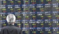 A businessman looks at an electronic share indicator at the window of a securities company in Tokyo on April 24, 2017. AFP / Toshifumi Kitamura
