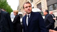 French presidential election candidate for the En Marche ! movement, Emmanuel Macron (C) leaves the Paris Police Prefecture building after attending a ceremony honouring the policeman killed by a jihadist in an attack on the Champs Elysees, on April 25, 2
