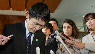 Surrounded by reporters, Japan's Disaster Reconstruction Minister Masahiro Imamura bows after submitting his resignation to Prime Minister Shinzo Abe at Abe's official residence in Tokyo on April 26, 2017. Japan OUT / AFP / JIJI PRESS / STR