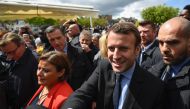 French presidential election candidate for the En Marche ! movement Emmanuel Macron (R) shakes hands with people as he arrives to visit the Whirlpool factory in Amiens, northern France, on April 26, 2017.  AFP / Eric Feferberg