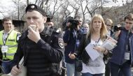 Open Russia movement coordinator Maria Baronova (2nd R), surrounded by journalists and an Interior Ministry officer, walks during a protest, calling for Russian President Vladimir Putin not to run for another presidential term next year, in central Moscow