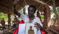 Congolese artist Cedrick Tamasala, vice president of the (CAPTC) Congolese Plantation Workers Art League, displays his first artwork made during a workshop in 2015 at the Kibangu Camp in Lusanga on April 21, 2017. AFP / Junior D. KANNAH
