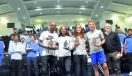 Athletes who are in Doha to compete in tomorrow's Diamond League pose for a group photo along with the coaches and students during their visit to Aspire Dome in Doha yesterday. Qatar Athletics Federation (QAF) and the Diamond League arranged the event.