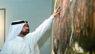 Katara General Manager Dr Khalid bin Ibrahim Al Sulaiti examines one of the paintings at the opening of the exhibition by renowned Chinese artist Yu Hanyu at Katara, yesterday.