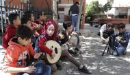 Syrian refugees from Minbej, nine-year-old Mostafa Abdallah (R) and thirteen year old Hanadi al-Hajj Abdallah (C) film a scene with their friends in Beirut's southern suburb of Shatila on April 5, 2017 as part of a refugee programme called the Refugee Fil