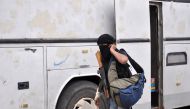 A Syrian opposition fighter arrives at a checkpoint manned by regime forces ahead of their evacuation from Waer neighbourhood, the last opposition-held district in the central city of Homs, on May 20, 2017. AFP / STRINGER
