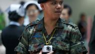 A Thai military personnel uses a video camera to make a record of visitors at an entrance of the Phramongkutklao Hospital in Bangkok, Thailand, May 23, 2017. REUTERS/Chaiwat Subprasom