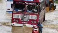 A Sri Lankan commuter pushes his motorbike through floodwaters on an expressway in the suburb of Athurugeriya in the capital Colombo on May 26, 2017. (AFP / Ishara S KODIKARA)