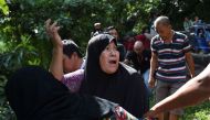 A woman calls out to her relatives after identifying bodies dumped off a cliff along the highway leading to Marawi on the southern island of Mindanao on May 28, 2017. AFP / Ted Aljibe 