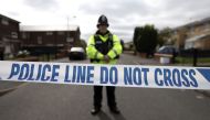 A police officer guards the entrance to a street in the Moss Side area of Manchester on May 28, 2017 during an operation. AFP / JOHN SUPER