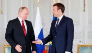 French President Emmanuel Macron (R) shakes hands with Russian President Vladimir Putin (L) at the Chateau de Versailles as they meet for talks in Versailles on May 29, 2017.  AFP / PHILIPPE WOJAZER
