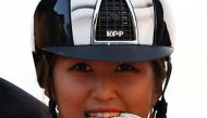 FILE PHOTO: South Korea's Chung Yoo-ra, then known as Chung Yoo-yeon, bites her gold medal as she poses after winning the equestrian Dressage Team competition at the Dream Park Equestrian Venue during the 17th Asian Games in Incheon September 20, 2014. RE