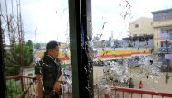 A policeman stands on guard behind a window full of bullet holes as government soldiers assault the Maute group in Marawi City, Philippines May 31, 2017. REUTERS/Romeo Ranoco TPX IMAGES OF THE DAY
