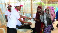 A Qatar Charity volunteer handing over food to a needy in Somalia. 