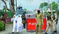 Kashmiri students walking past Indian government forces standing guard in central Srinagar, yesterday. Indian paramilitary forces killed four suspected suicide attackers who tried to storm their camp in the Kashmir region, yesterday.