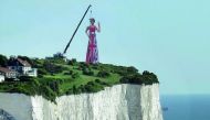 A giant scaffolding sculpture with an image of Britain's Prime Minister, Theresa May, wearing the Union Flag and making a gesture towards continental Europe is seen on top of the cliffs overlooking the south coast of England and the Channel, yesterday.
