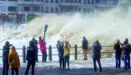 People stand over the bridge as the huge waves hit coastline during the heavy storm in Cape Town, yesterday.